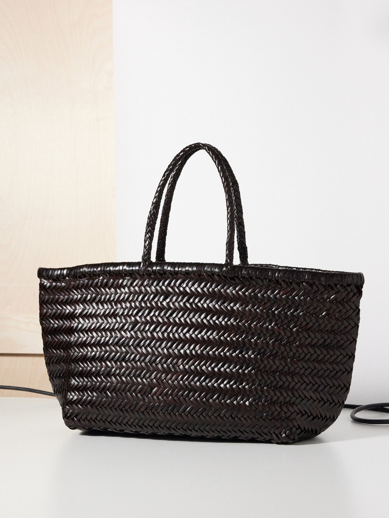 Leather strips are tightly woven by artisans in India for Dragon Diffusion’s coffee-brown Triple Jump basket bag, which will develop a unique patina with time.