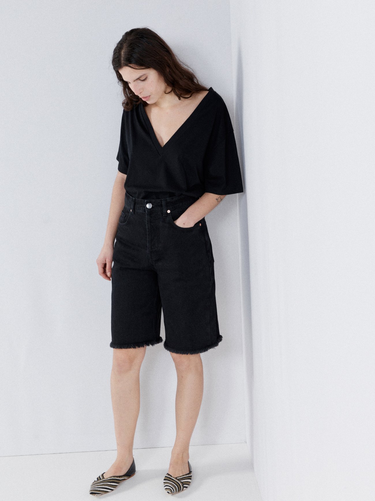 Raey’s longline black 90s denim shorts are made from mid-weight organic-cotton denim with a high-rise waist and five pockets, capturing the retro mood.