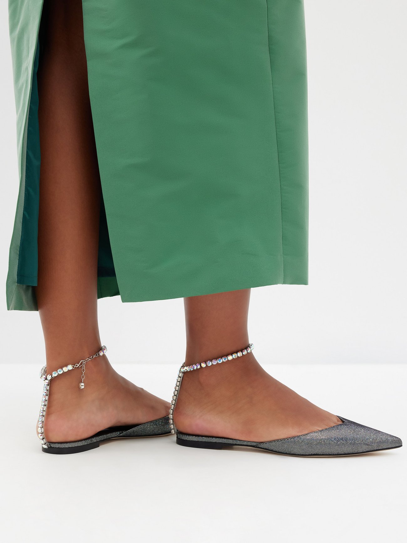 Bring some sparkle to your footwear collection with Jimmy Choo’s Saeda point-toe flats – crafted from metallic silver suede and finished with a crystal-bracelet ankle strap.