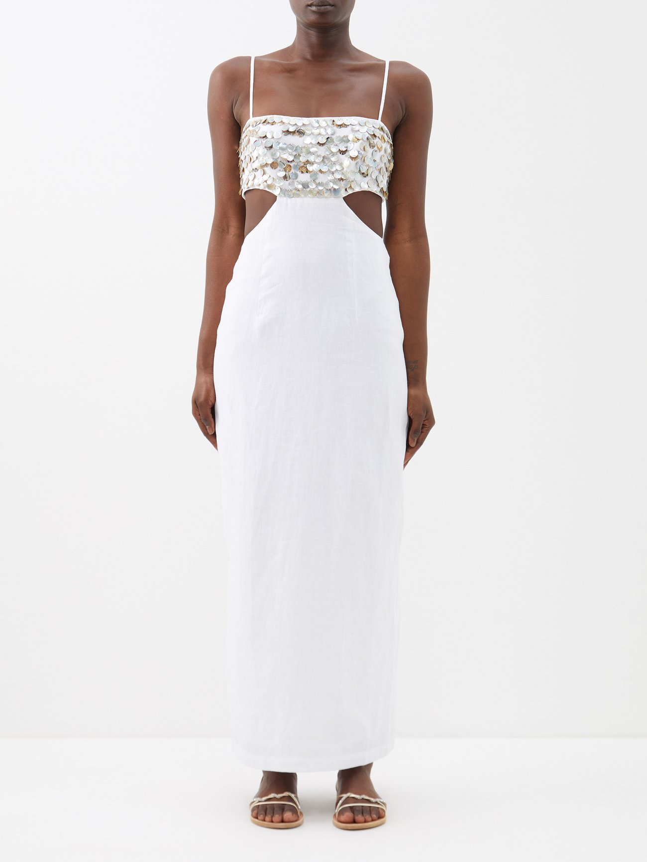 Spice up your summer party looks 
 with Staud's white Jada maxi dress with waist cutouts and mother-of-pearl paillettes that embellish the body.