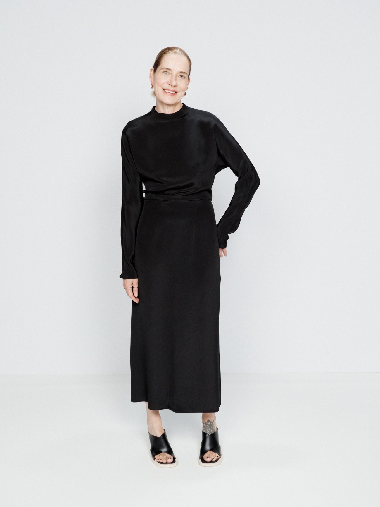 Raey's black dress is draped from heavy double-faced silk and shaped with a cowl-neck, dolman sleeves and an open back.