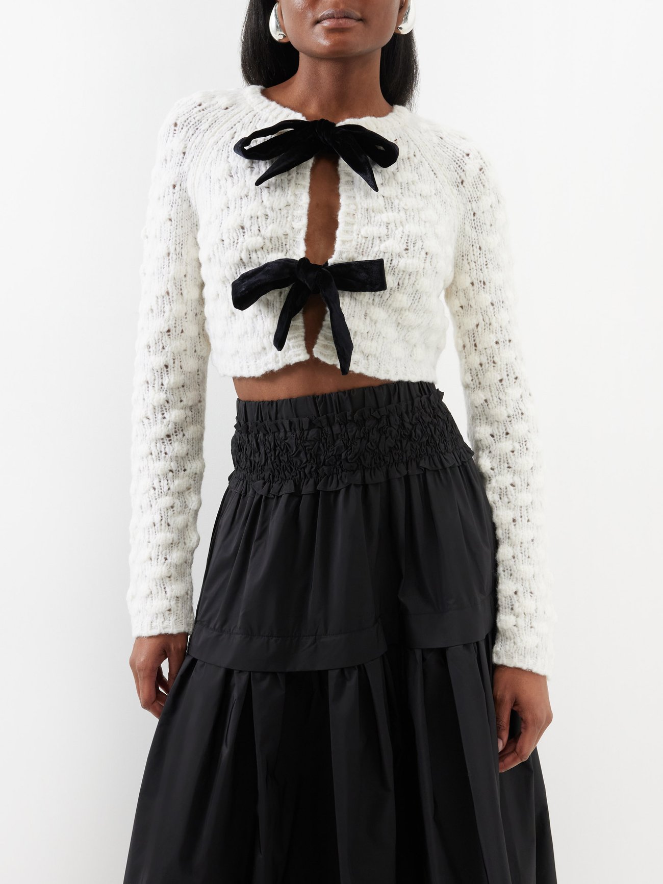 Notes of romance permeate Sea's white Teresa cropped cardigan, knitted from a soft wool blend and accented with a pair of black velvet bow ties.