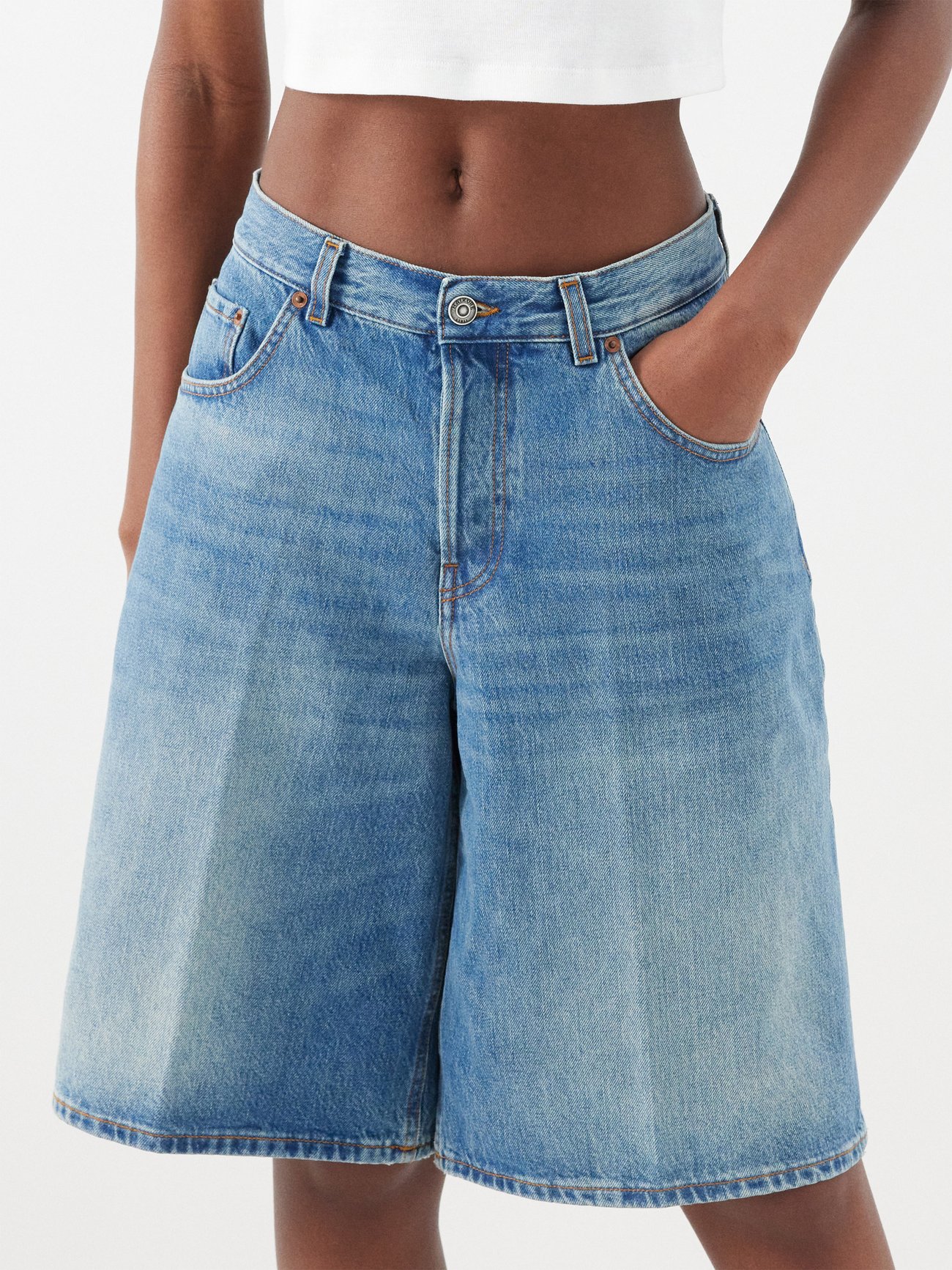 jorts trend 2024 - Haikure’s elevated take on the Bermuda shorts, this blue high-rise Becky pair are crafted in cotton denim and stamped with a leather logo patch.