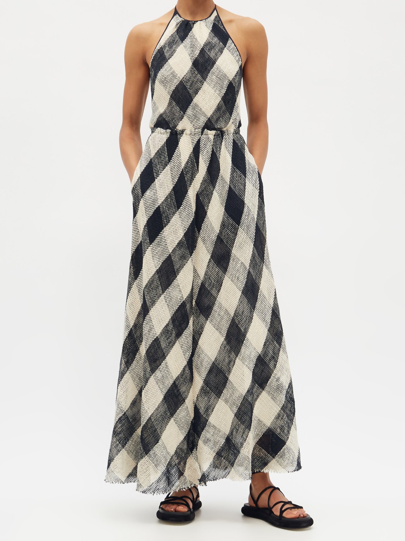 Raey's navy and cream checked maxi dress is shaped from open-weave cotton, imparting it with a rustic mood. It's made in the UK to a halterneck silhouette with an elasticated waist and a full skirt complemented by a raw hem, then lined in silk chiffon.