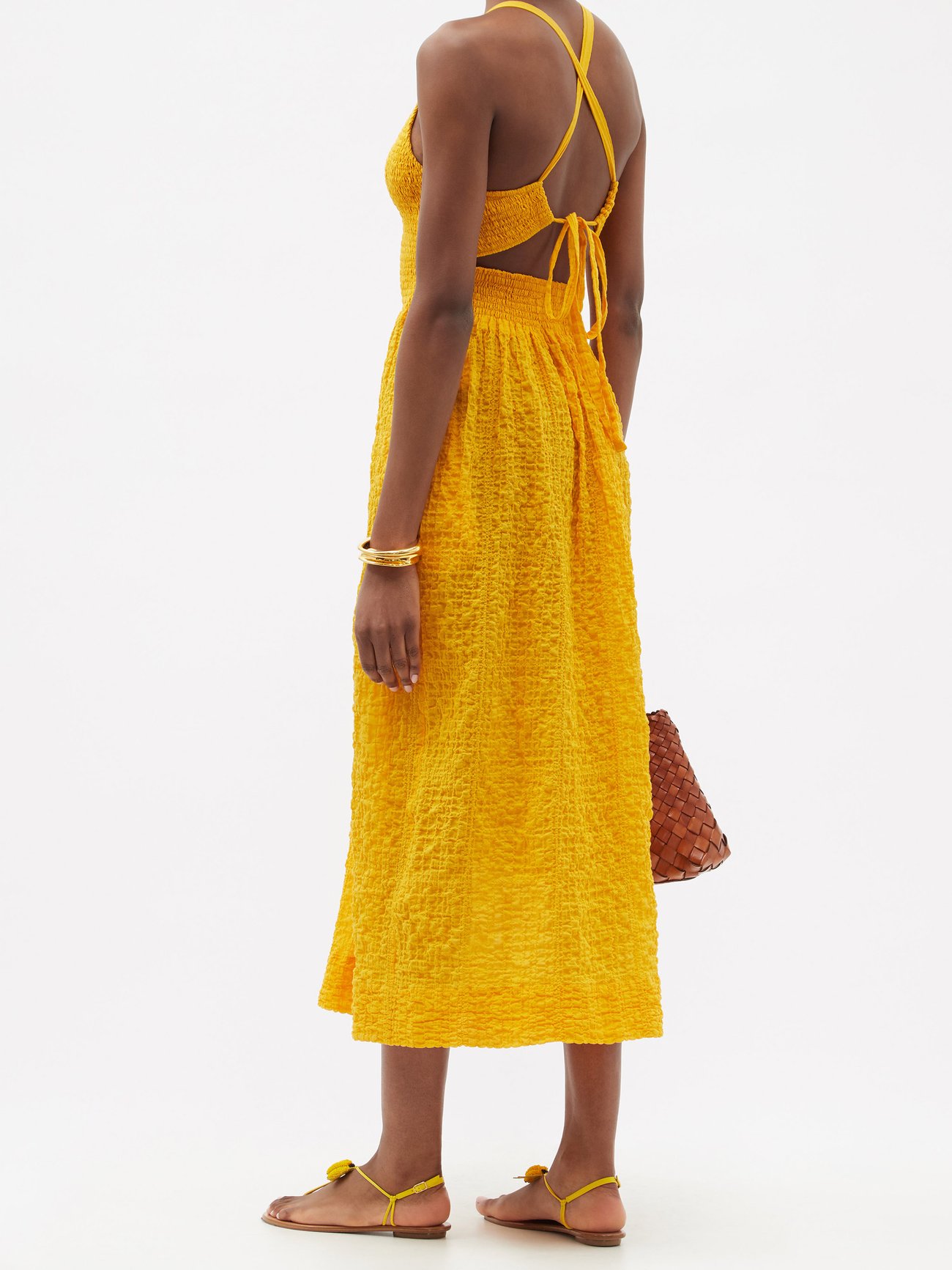 THREE GRACES LONDON Soleil tie back cotton-blend seersucker midi dress in yellow has a shirred bodie and ties at the open back. Relaxed fit midi skirt.