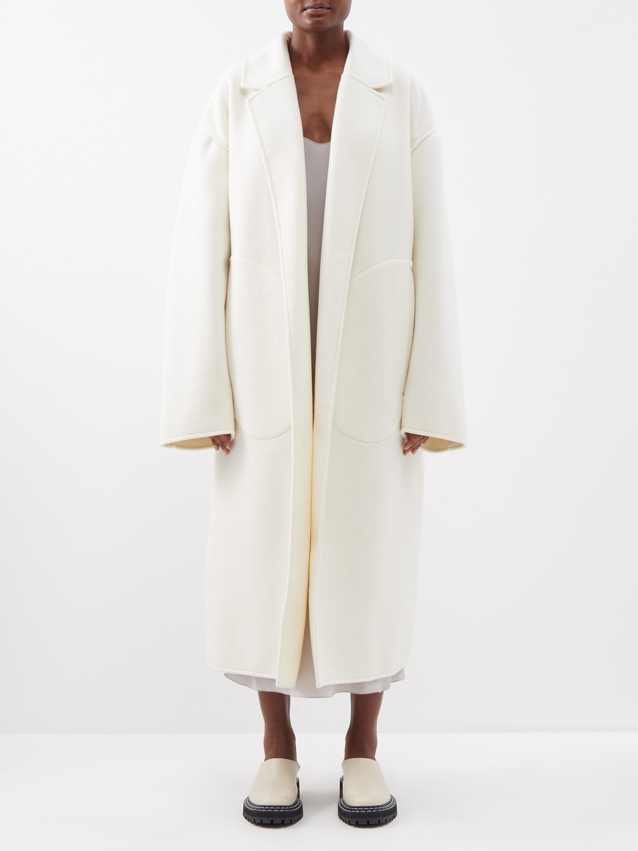 Raey exaggerated shoulder long wool coat in pristine cream. This coat has extra long sleeves, large side pockets and soft finishes. 