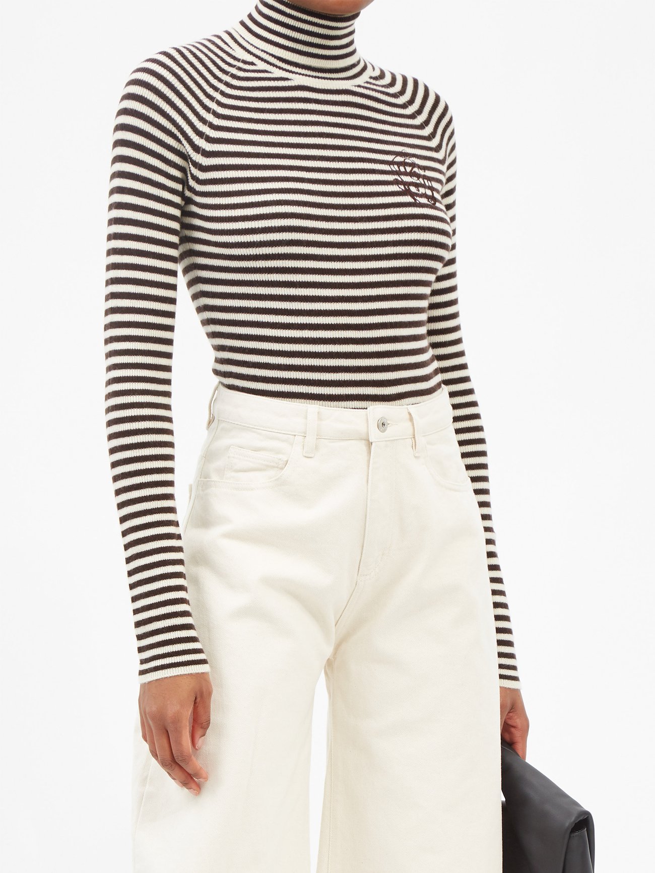 Ganni black cashmere-merino sweater is punctuated with white stripes featuring a roll neckline and raglan sleeves, capturing Detti Reffstrup’s Scandi-cool aesthetic.