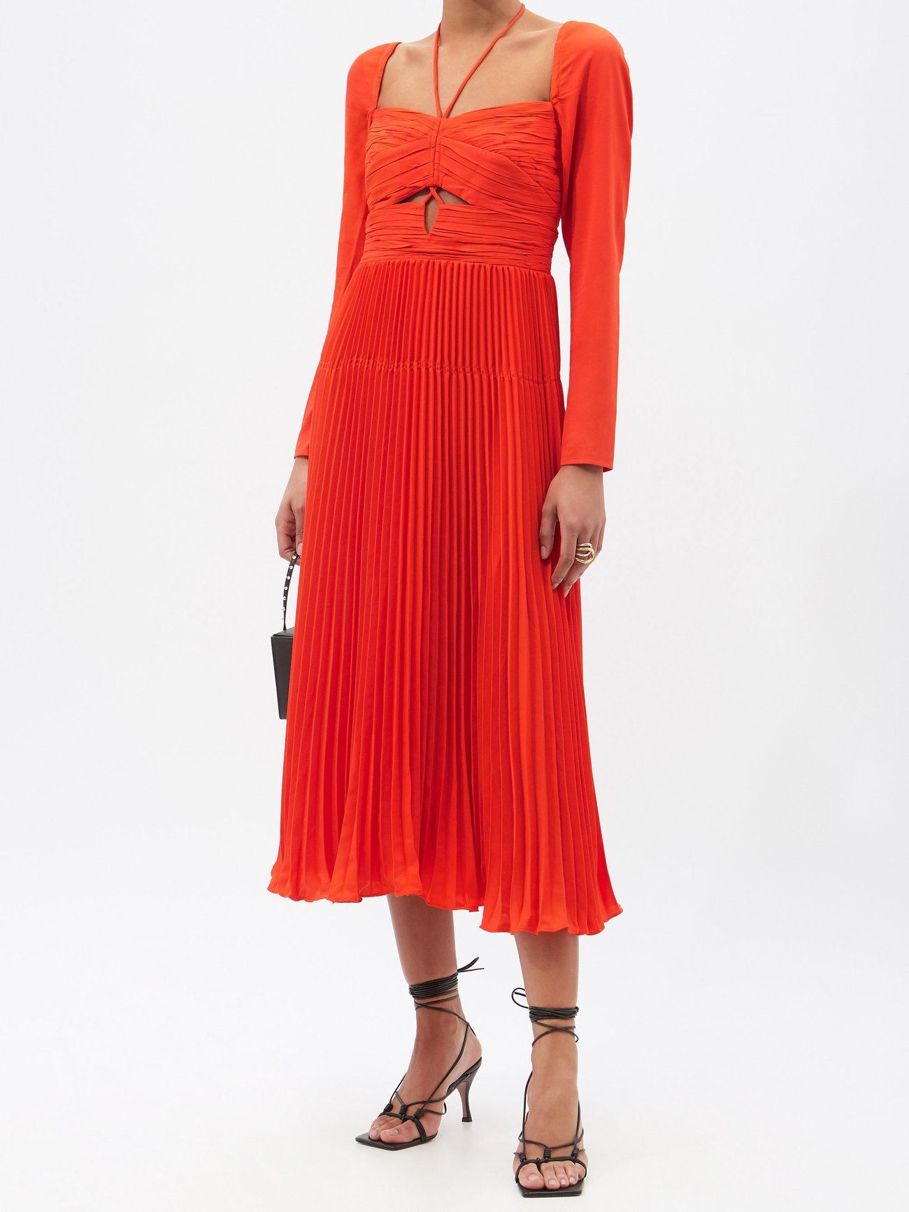 Self-Portrait’s red dress has a ruched sweetheart-neck bodice that’s accented with a cutout, then falls in a series of crisp pleats to a midi hem. Invisible zip back. 