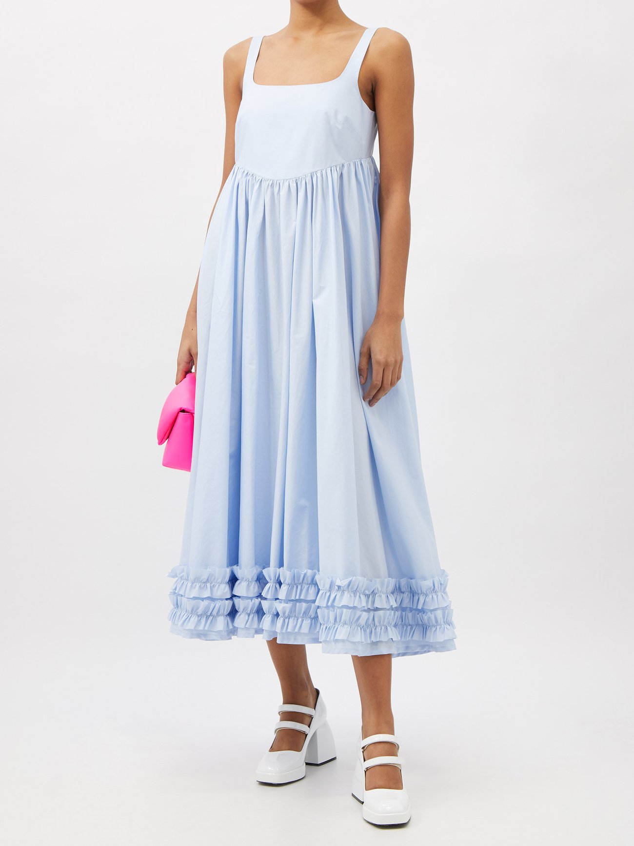 Made in England from lightweight cotton poplin, this light blue midi dress evokes a retro mood with the gently ruffled hem and scooped back cut. Fitted lightly under the bust with a roomy skirt and mid thickness straps. 