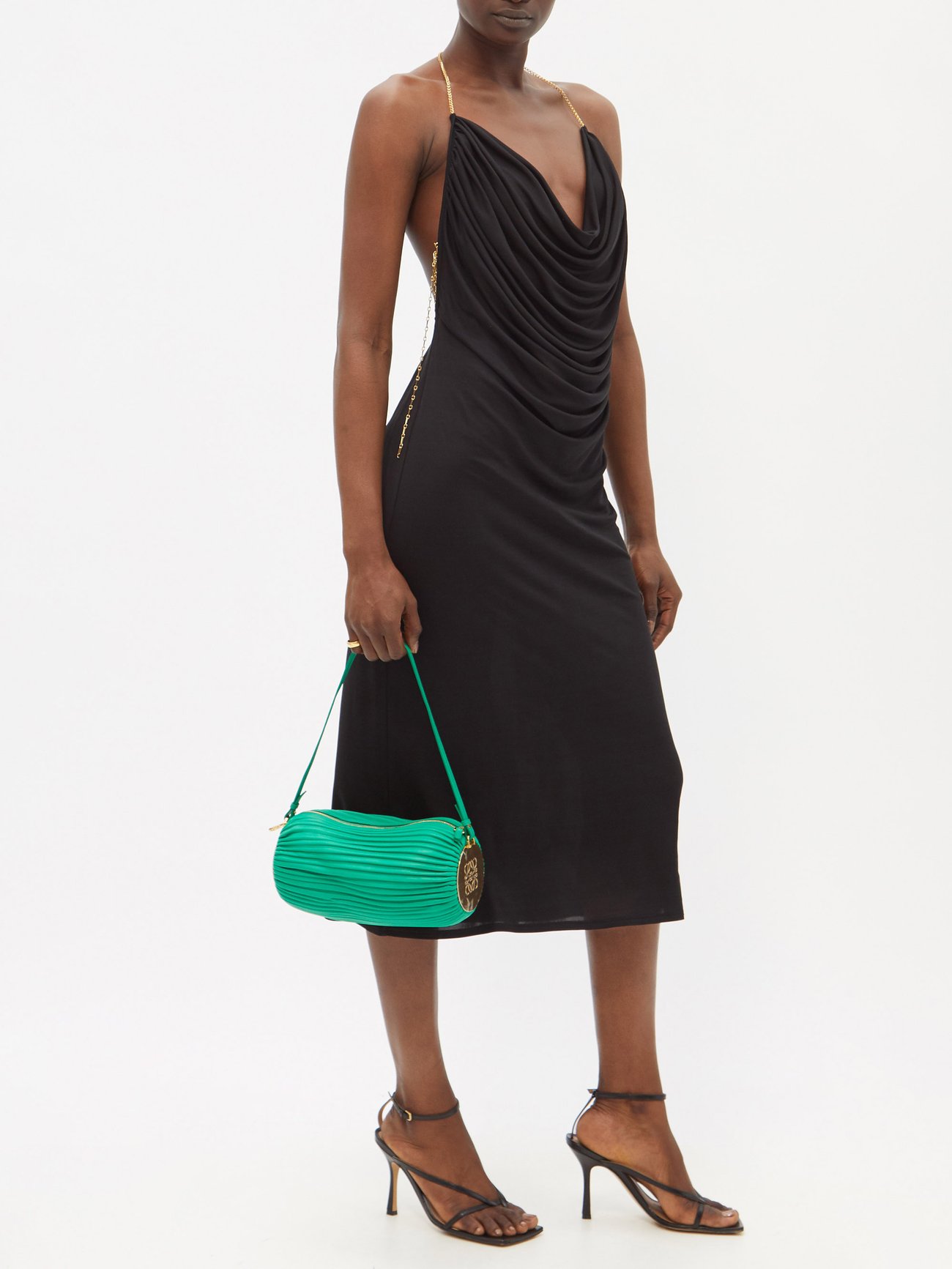 Loewe’s black cowl-neck silk-satin dress features elegant gold halterneck and low back with gold chain detail. 