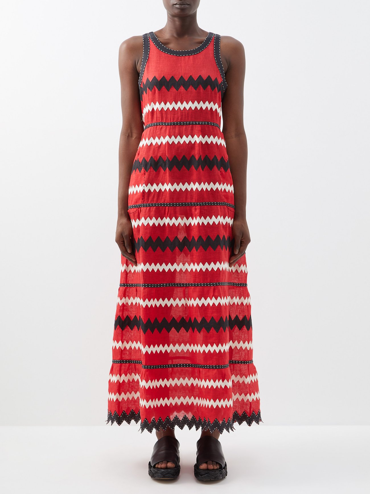 Vita Kin's red Ola dress is crafted from airy linen to a relaxed silhouette and appliquéd with black and white zigzags, celebrating the label's artistic outlook. It is sleeveless with a round neck, cinched waist, fuller skirt and maxi hemline. 