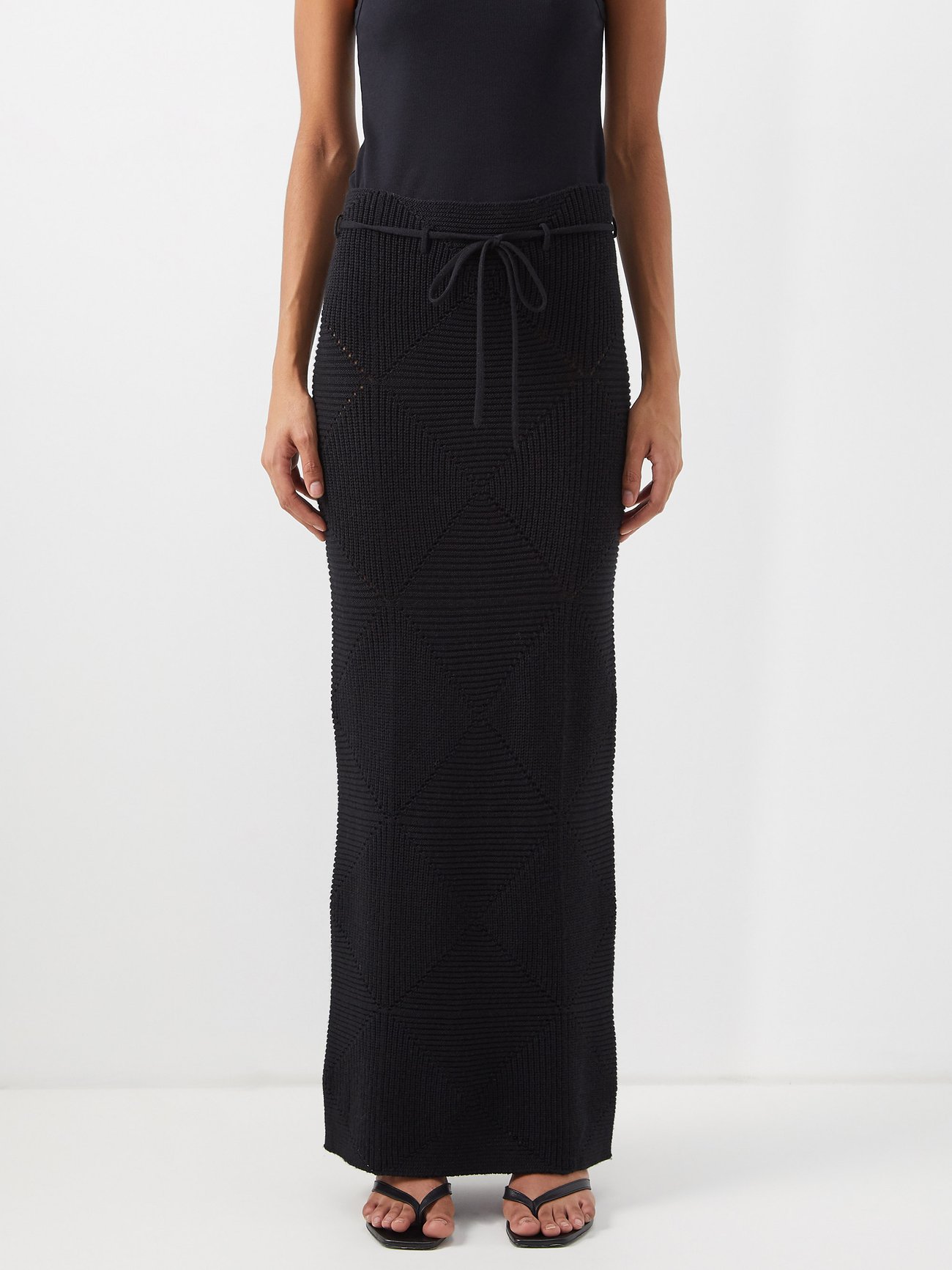 Tick off the maxi skirt trend for 2022 with Toteme’s black maxi skirt is knitted to a 1990s-inspired tube silhouette from a blend of wool and silk, and cinched with a slender tie at the waist.