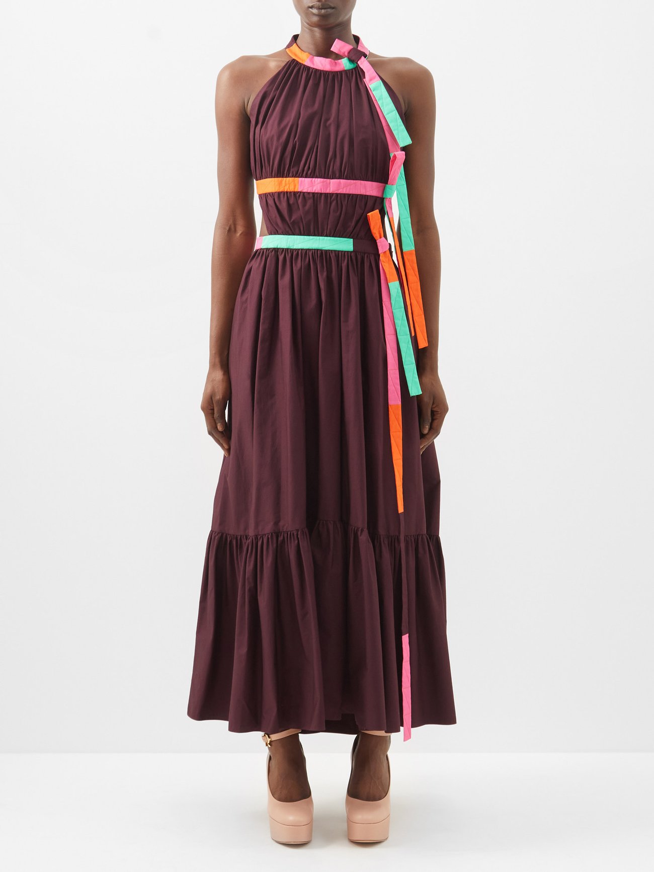 Roksanda’s aubergine-purple cotton Niesha dress features a back cutout and bright trims that form bows and waist-defining accents, adhering to the label’s colour-blocking vision. Lower back cut out and tie round high neck halterneck. Maxi length. 