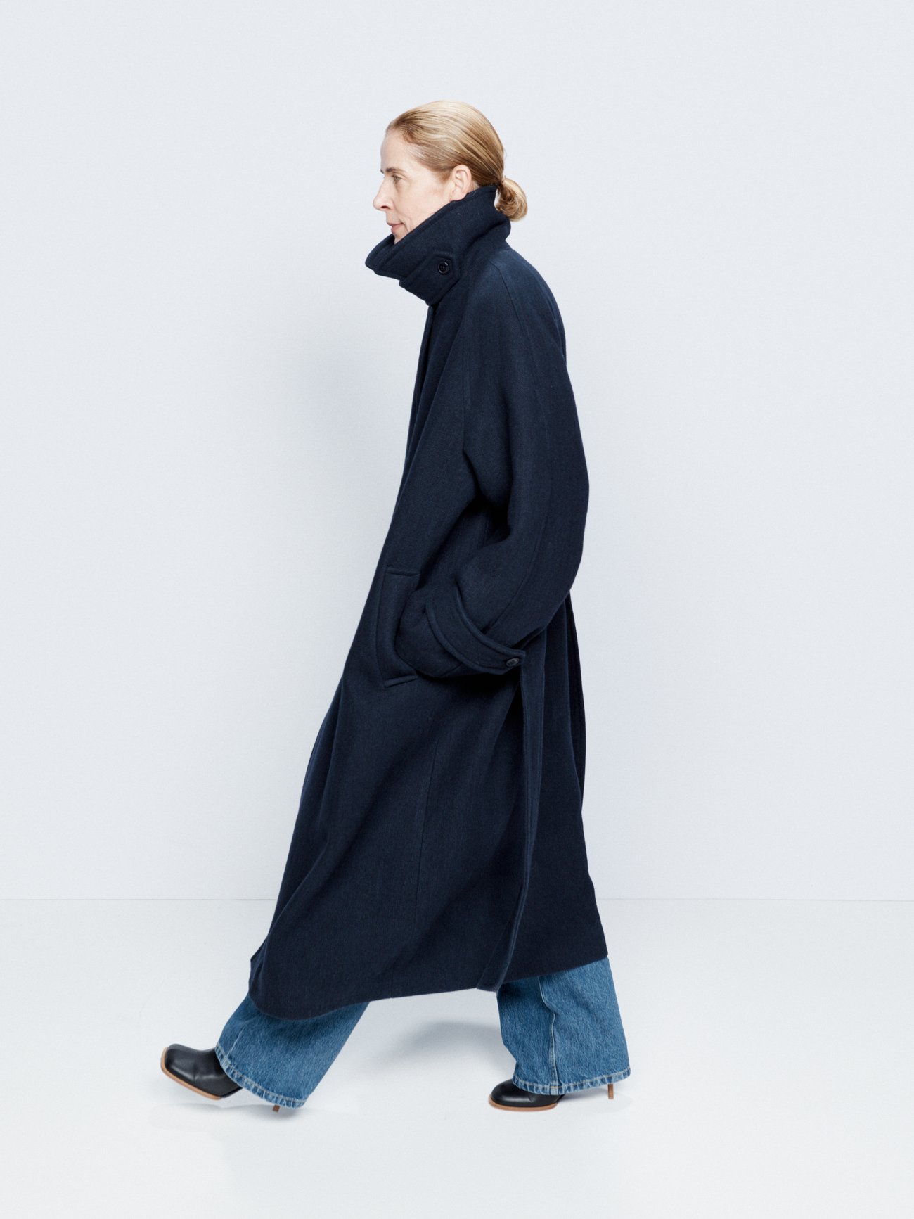 Raey's navy overcoat is shaped to a generous silhouette from robust twill, with draped raglan sleeves and a cinching waist belt.