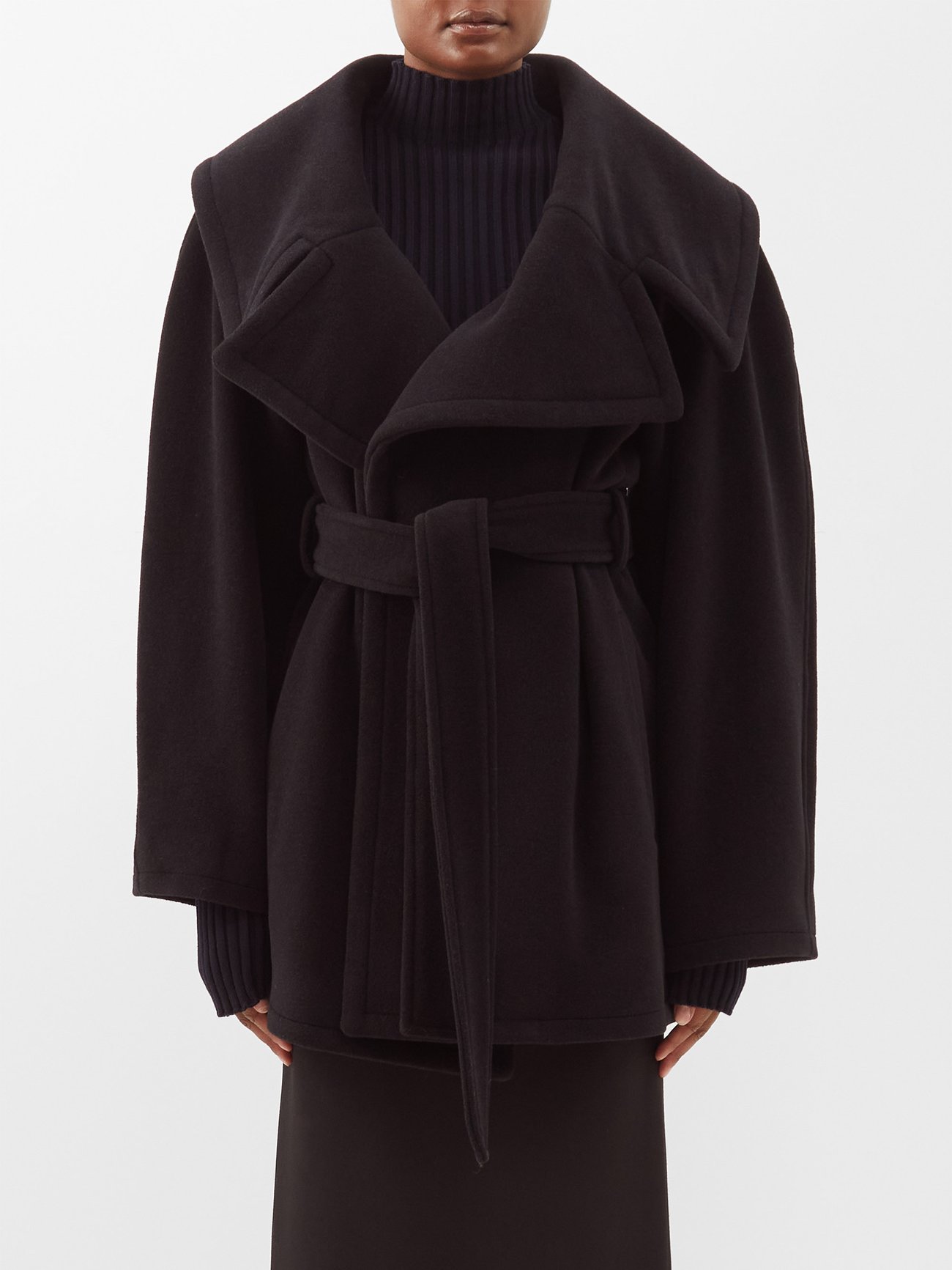 Balenciaga’s black alpaca and wool-blend felt coat features exaggerated notch lapels that envelope the shoulders and an elegant wrap shape that's cinched with the self-tie belt.