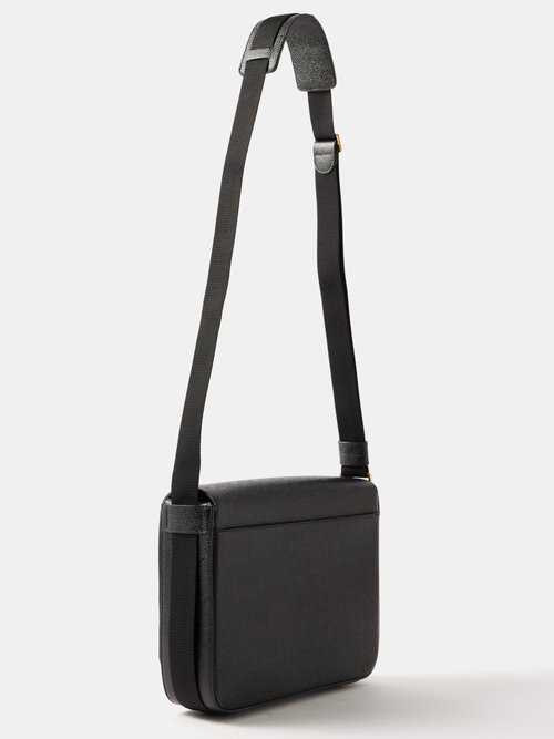 Jin carries a Thom Browne bag, made of black gravel leather, with a st