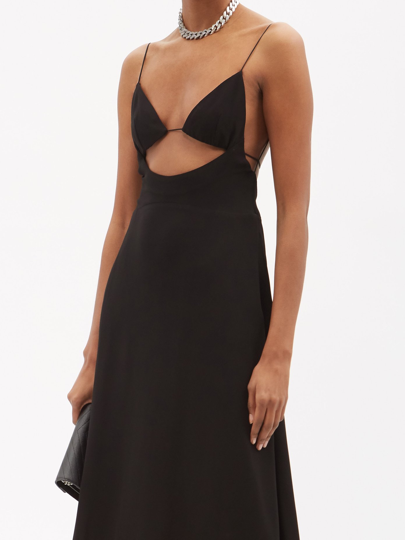 Anthony Vaccarello's seductive vision perfectly translates to Saint Laurent’s black crepe dress, defined by a front cutout and low back framed with spaghetti straps.