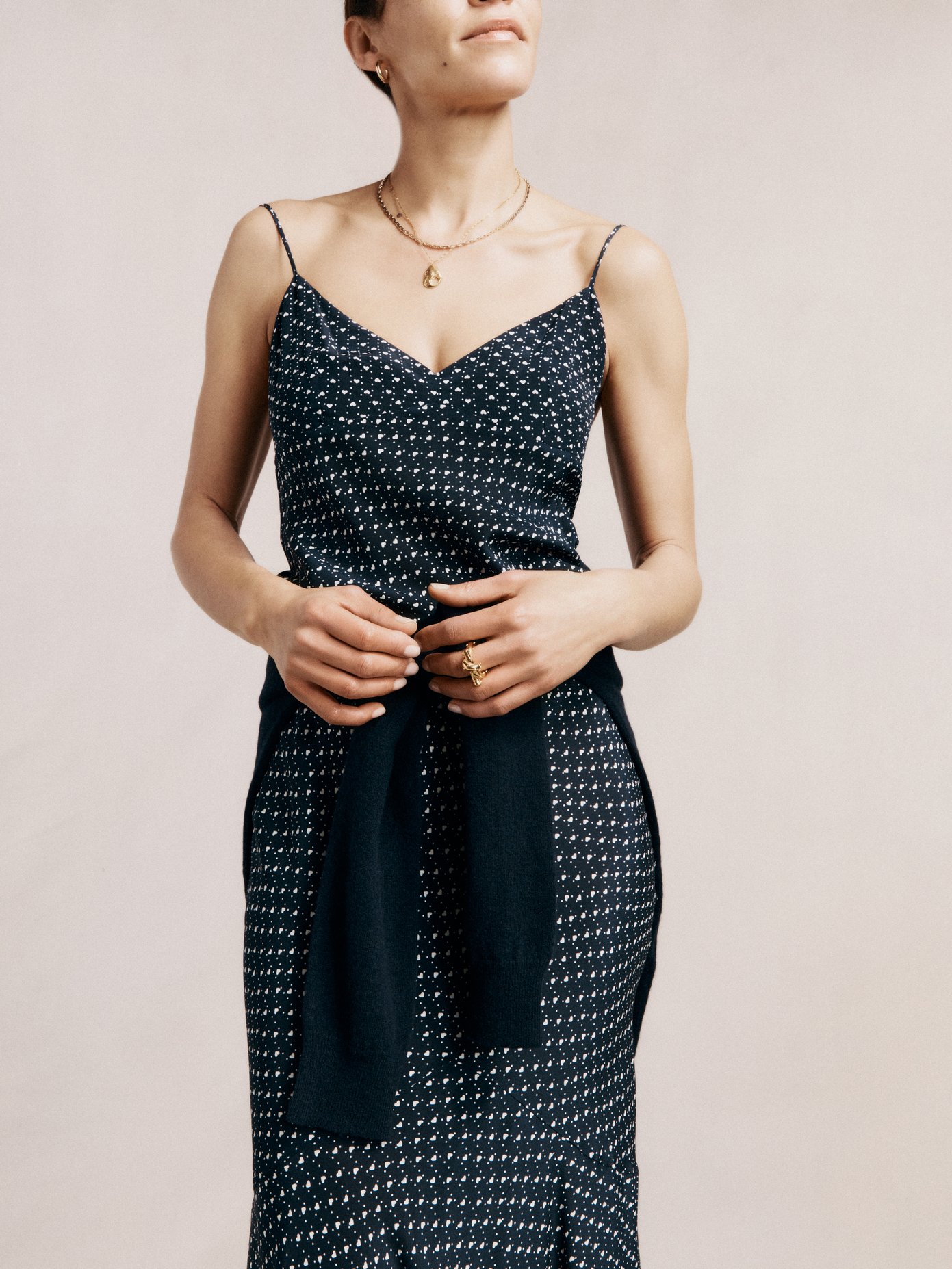 Raey's navy silk maxi dress is shaped with a deep V-neckline and sweeping fishtail hem, complete with a ditsy print comprised of miniature white hearts and polka dots.


